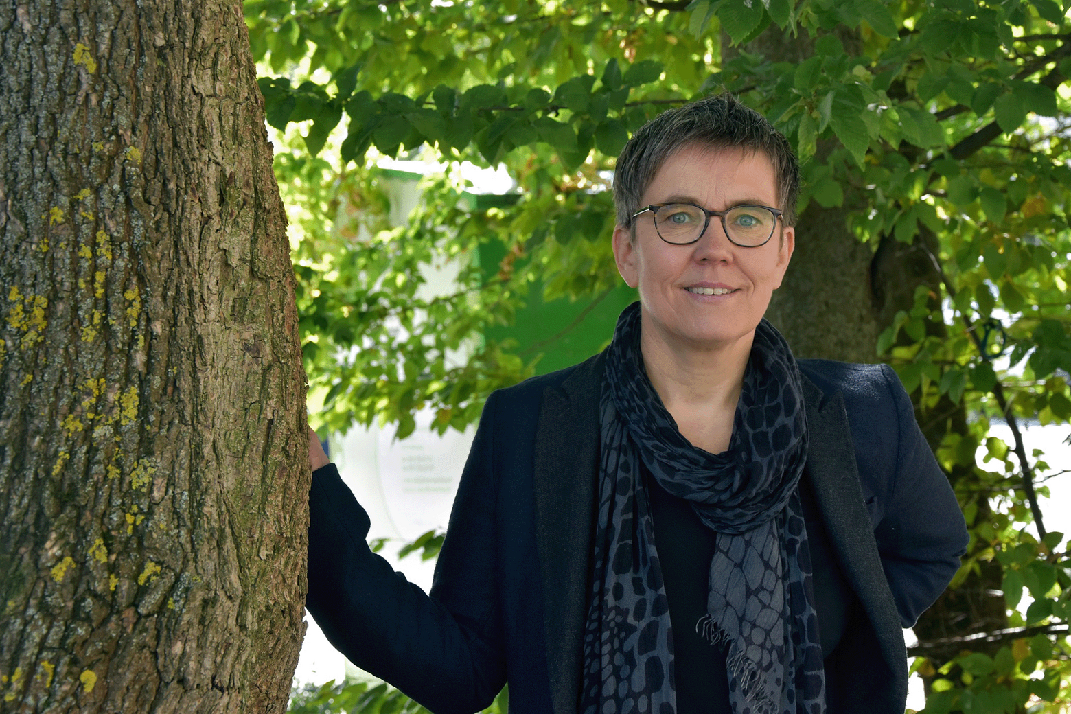 Nadia Fiedler steht neben einem Baum und lächelt in die Kamera.