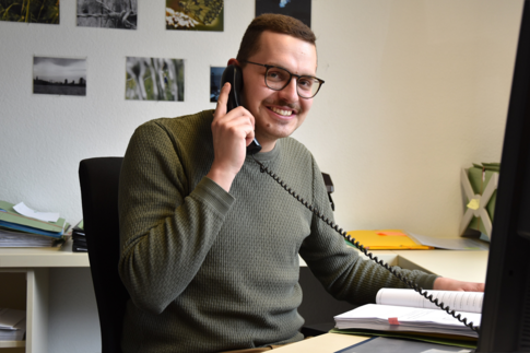 Stephan Hohnerlein sitzt telefonierend an seinem Arbeitsplatz in der Strafentlassenenhilfe